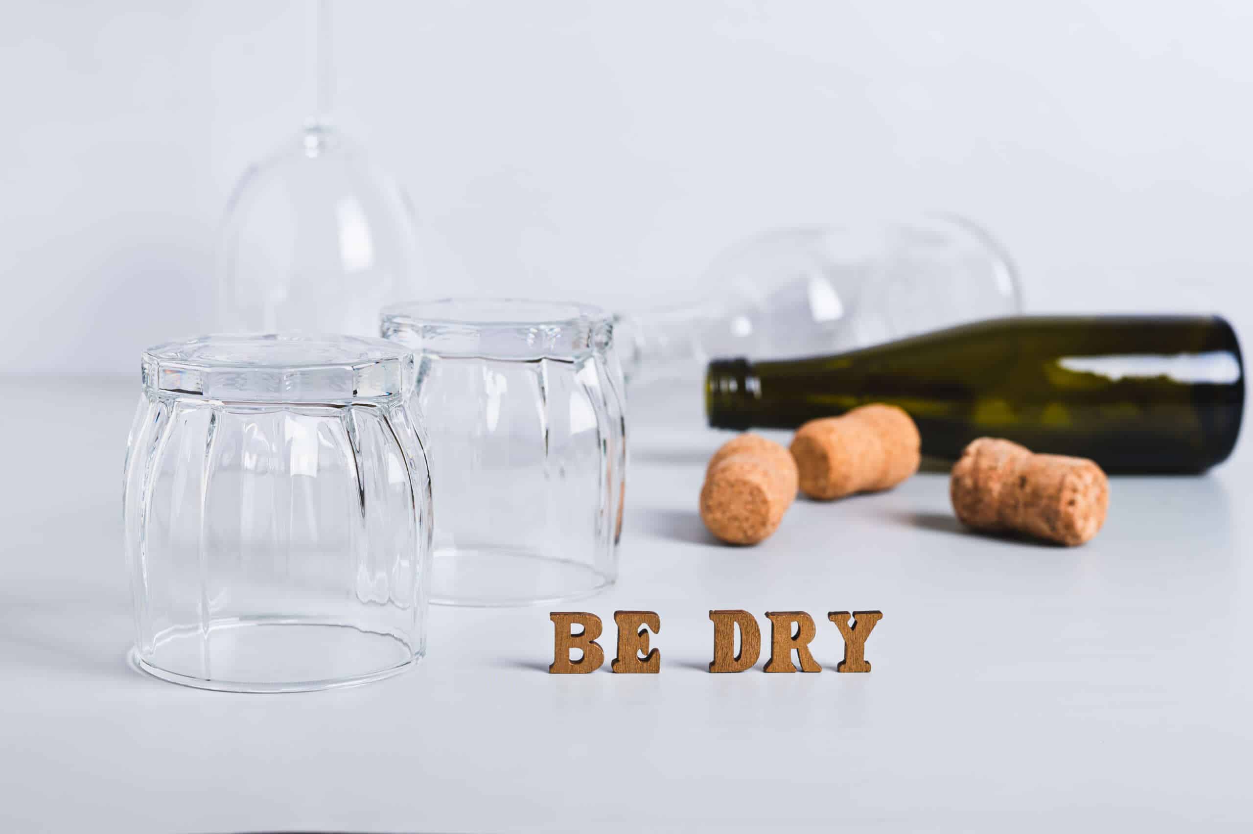 an empty bottle, glasses and corks to represent the dry january experience